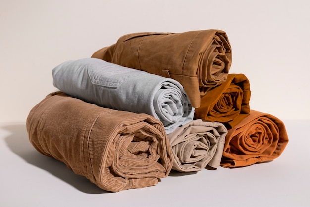 A stack of neatly rolled fabric pieces in earthy tones, including brown, gray, beige, and orange.