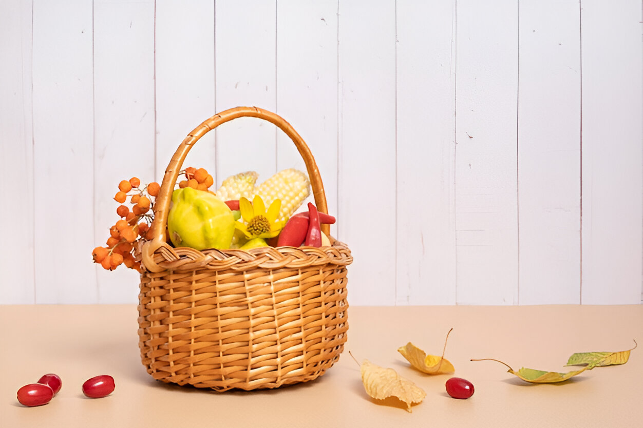 Classic woven basket filled with decorative fruits and flowers, perfect for autumn.