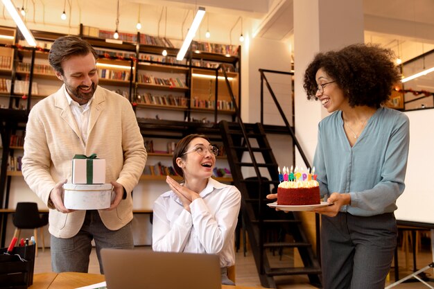 Medium shot of coworkers smiling and celebrating together at work in office setting.