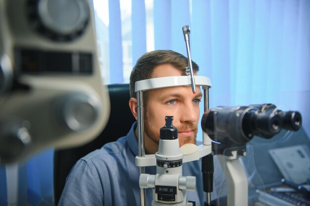 Patient sitting at an eye clinic with a slit lamp device as the eye specialist performs a precise vision and eye health check.